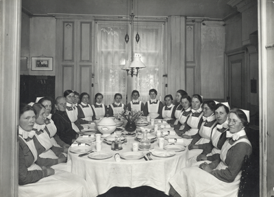 826182 Groepsportret van proefzusters (diaconessen in opleiding) aan een eettafel in het Diakonessenhuis (Oudegracht ...